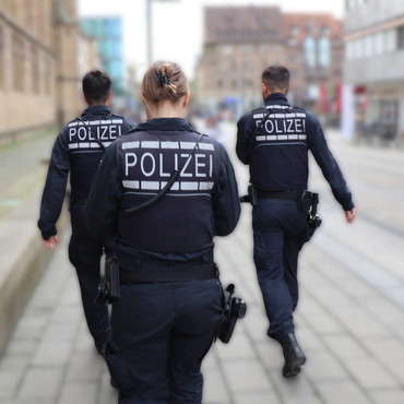 Schmuckbild - Polizisten laufen durch die Innenstadt