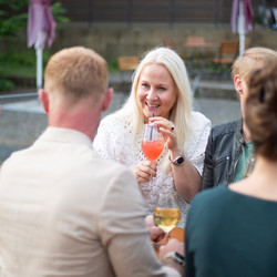 Eine Gruppe Menschen sitzt gemütlich zusammen und trinkt Wein
