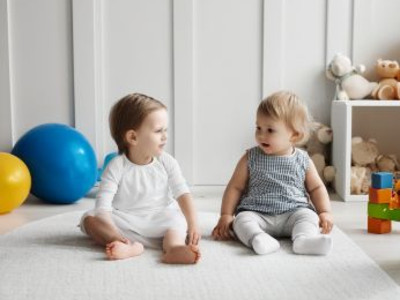 Man sieht zwei Kleinkinder bei einer Krabbelgruppe/ KI generiertes Bild