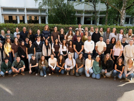 Eine große Gruppe neuer Auszubildender und Studierender der Stadt Heilbronn steht gemeinsam im Freien vor einem Gebäude.