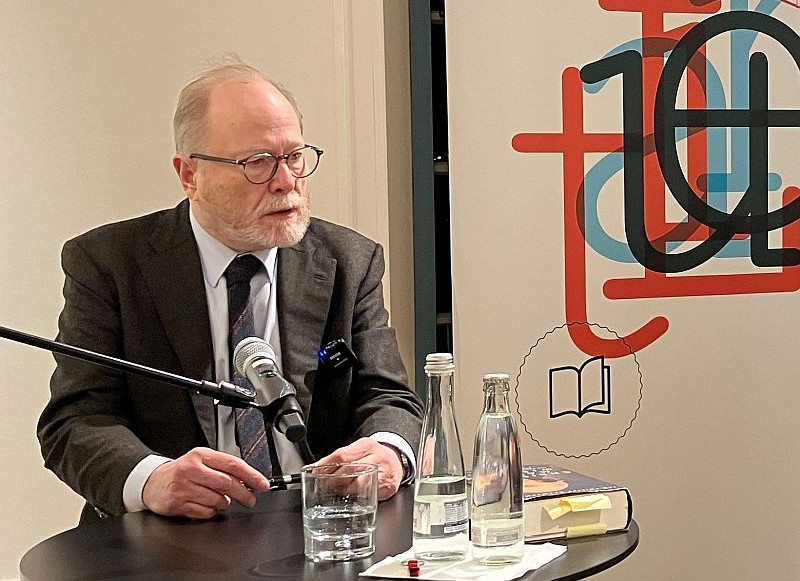 Das Bild zeigt den bekannten Autor Jan Philipp Reemtsma an einem Tisch mit Mikrofon bei einer Lesung im Literaturhaus Heilbronn.