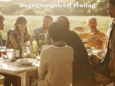 Man sieht verschiedene Menschen an einem Tisch sitzen und sich unterhalten.