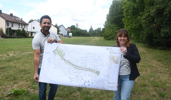 Zwei Stadt- und Raumplaner zeigen einen großen Plan für die Entwicklung des Baugebiets Friedrich-Ebert-Trasse. iesenareal sind neue Wohnflächen geplant.