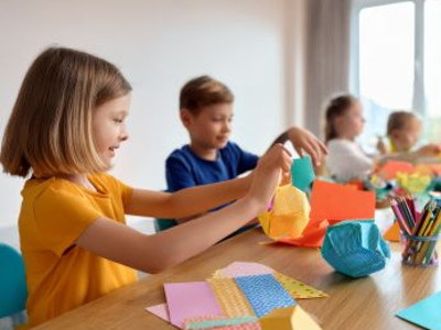 Man sieht mehrere Kinder basteln. KI generiertes Bild