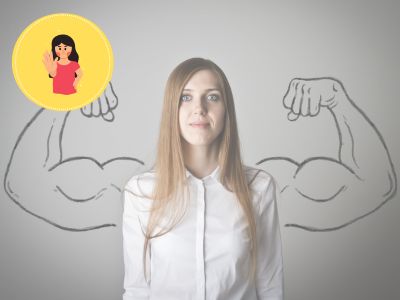 Man sieht eine Junge Frau die vor einer Wand steht, auf der starke Arme abgebildet sind.