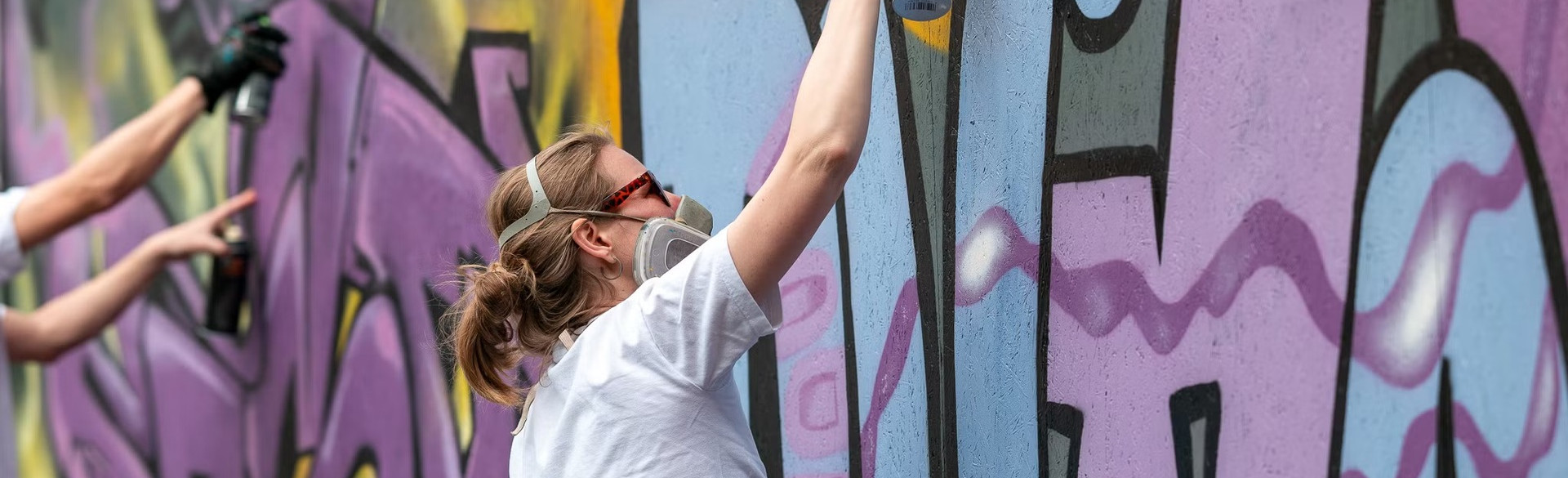 Person bemalt die Wand mit Graffiti